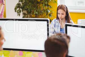 Confident businesswoman working on computer at creative office