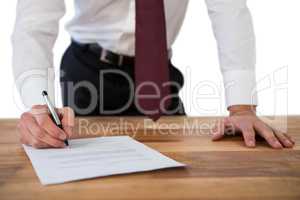 Businessman filling last will and testament form against white background