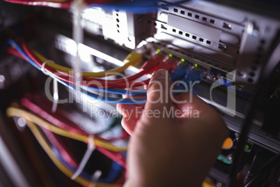 Close-Up of technician plugging patch cable in a rack mounted server