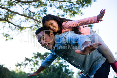 Father giving piggyback ride to his daughter