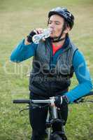 Male mountain biker drinking water