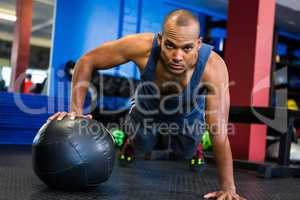 Serious man doing push-ups with exercise ball