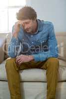 Depressed man sitting on sofa