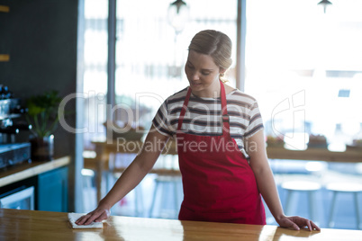 Waitress wiping table at counter