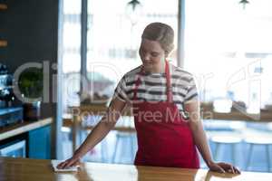 Waitress wiping table at counter