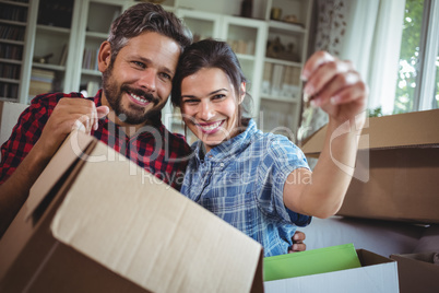 Smiling couple holding keys in their new house