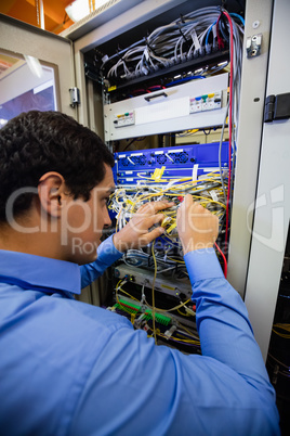 Technician checking cables in a rack mounted server