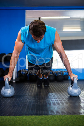 Man doing push-ups with kettlebell