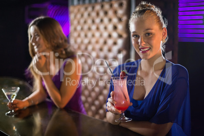 Woman having glass of cocktail in bar