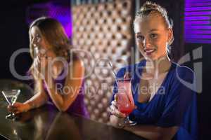 Woman having glass of cocktail in bar