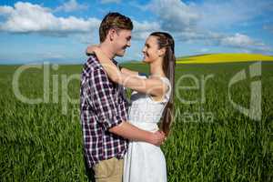 Romantic couple embracing each other in field