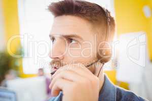 Close-up of executive interacting with headphones at creative office