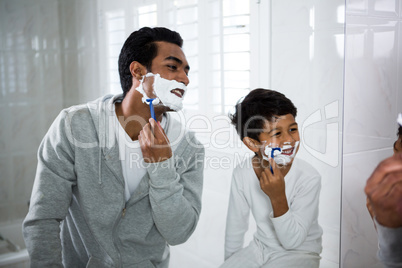 Father and son shaving together