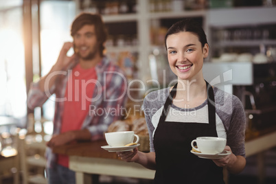 Portrait of waitress holding coffee cups