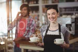 Portrait of waitress holding coffee cups