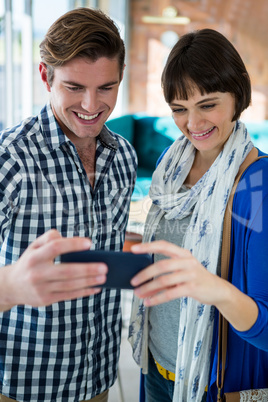 Smiling couple looking at the mobile phone