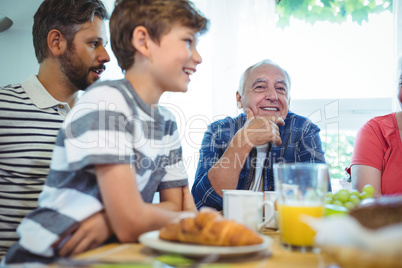 Multi-generation family sitting at breakfast table