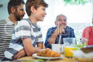 Multi-generation family sitting at breakfast table