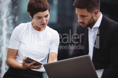 Businesspeople discussing over laptop