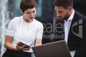 Businesspeople discussing over laptop