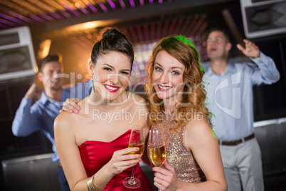 Portrait of female friends holding a glass of champagne