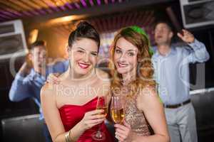 Portrait of female friends holding a glass of champagne