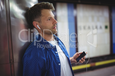 Handsome man listening song on mobile phone