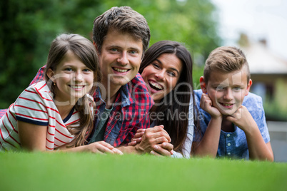 Portrait of happy family lying in park