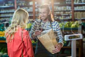 Man assisting woman in selecting vegetables