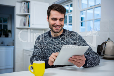 Man using digital tablet in the kitchen