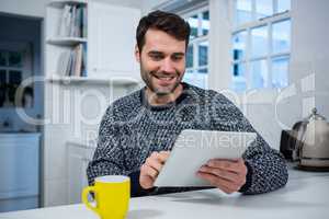 Man using digital tablet in the kitchen