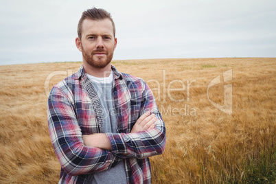 Portrait of farmer standing with arms crossed in the field