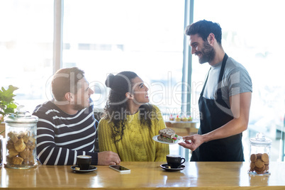 Waiter serving a plate of sandwich to customer