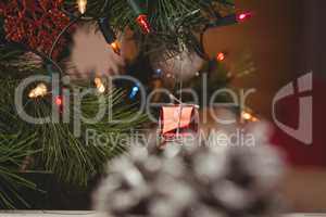 Fairy light and small gift box hanging on christmas tree