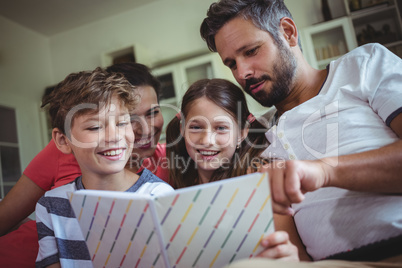 Smiling family looking at a photo album