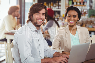 Man and woman using laptop during meeting