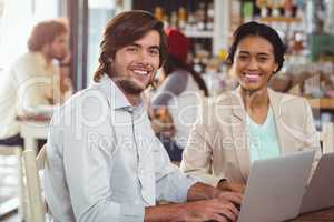 Man and woman using laptop during meeting