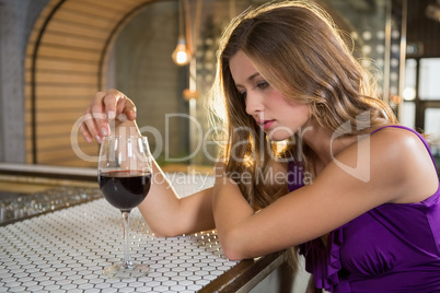 Thoughtful woman having red wine at bar counter