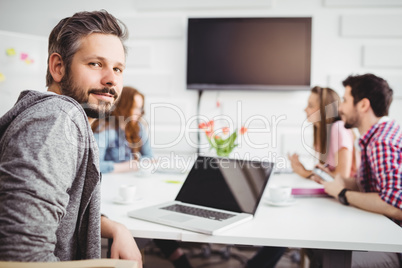 Portrait of confident executive in meeting at creative office