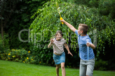 Kids playing with bubbles in the park