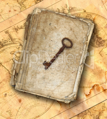 Old book and old rusty key on the old maps