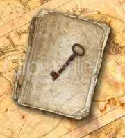 Old book and old rusty key on the old maps