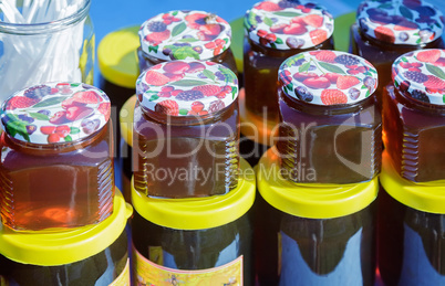 Different varieties of honey in banks, offered for sale at the f