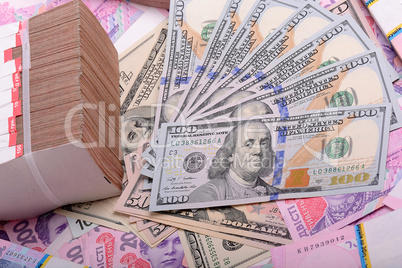 One hundred dollar bill on the background of ukrainian hryvnia