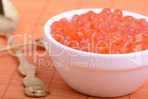 Caviar. Red caviar on a white plate. Gourmet food close up, appetizer