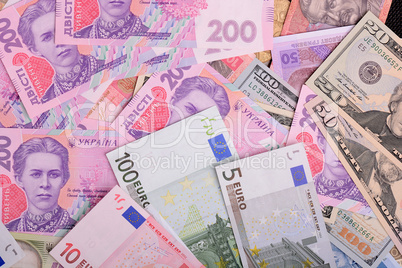 One hundred dollar bill on the background of ukrainian hryvnia and european euro