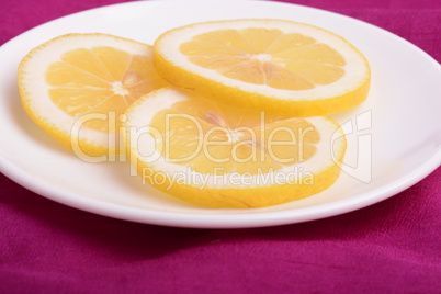 A slices of fresh yellow lemon. Lemon pieces in different sizes background