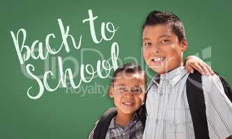 Hispanic Boys Wearing Backpacks In Front of Back To School Writt