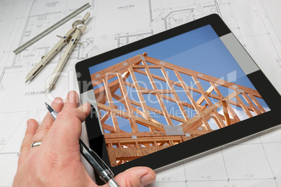 Architect Hand on Tablet Showing Home Framing Over House Plans