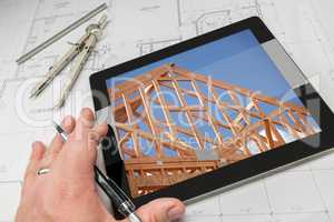 Architect Hand on Tablet Showing Home Framing Over House Plans